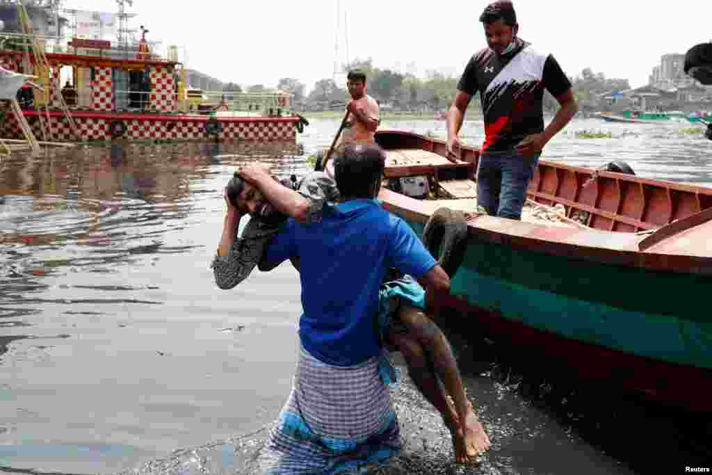 Relatives mourn after several people died as a ferry collided with a cargo vessel and sank in the Shitalakhsyaa River in Narayanganj, Bangladesh.