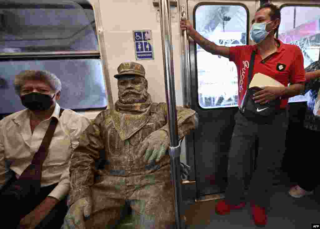 Mexican urban artist Miguel Moctezuma, aka "Don Ferro Ferrocarrilero," goes from one subway station to another during his performance disguised as a railroad worker, in Mexico City, June 6, 2022.