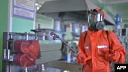 A health official disinfects the workplace floor at the Pyongyang Cosmetics Factory in Pyongyang, June 16, 2022. Several hundred families are suffering from an unidentified intestinal ailment, state media reported Friday, as North Korea also battles COVID-19.