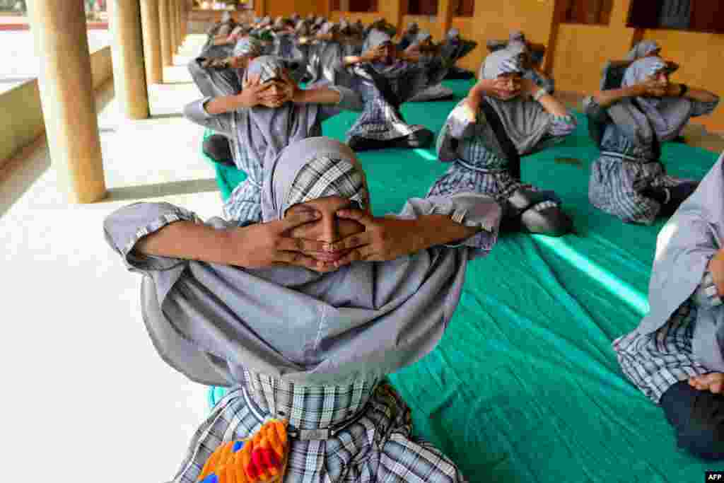 Students participate in a yoga practice session ahead of International Yoga Day, at a school in Ahmedabad, India.