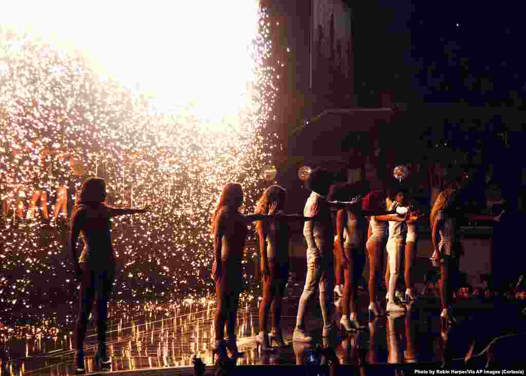 Beyoncé junto a su grupo de bailarines en un escenario iluminado por fuegos artificiales en Atlantic City.