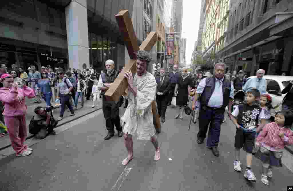 Prosesi "Perjalanan Menuju Salib" dalam perayaan Jumat Agung di Sydney, Australia (29/3). (AP/Rick Rycroft)