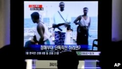 韩国人观看电视转播1月21日韩国部队夺回被挟持货轮的报道