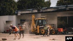 Esta fotografía tomada y publicada por la Administración Militar Regional de Dnipropetrovsk el 3 de julio de 2024 muestra a trabajadores comunales limpiando escombros luego de un ataque ruso en la ciudad de Dnipro, en medio de la invasión rusa de Ucrania.