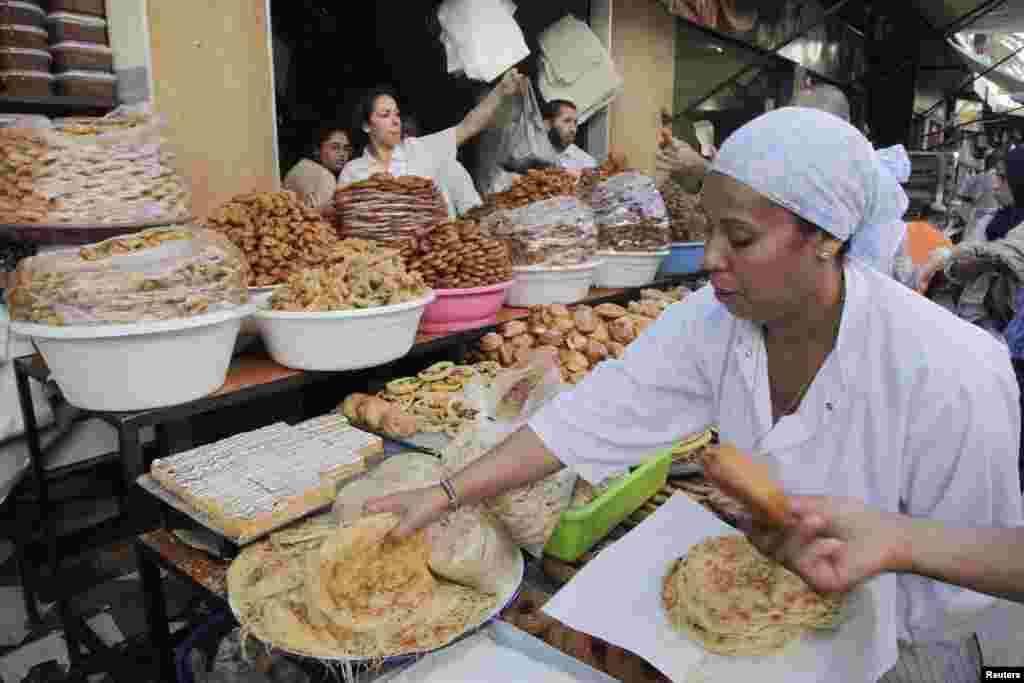 Seorang pedagang menjual aneka kue tradisional terbuat dari tepung dan madu yang digoreng menjelang Ramadan di Rabat, Maroko (8/7).
