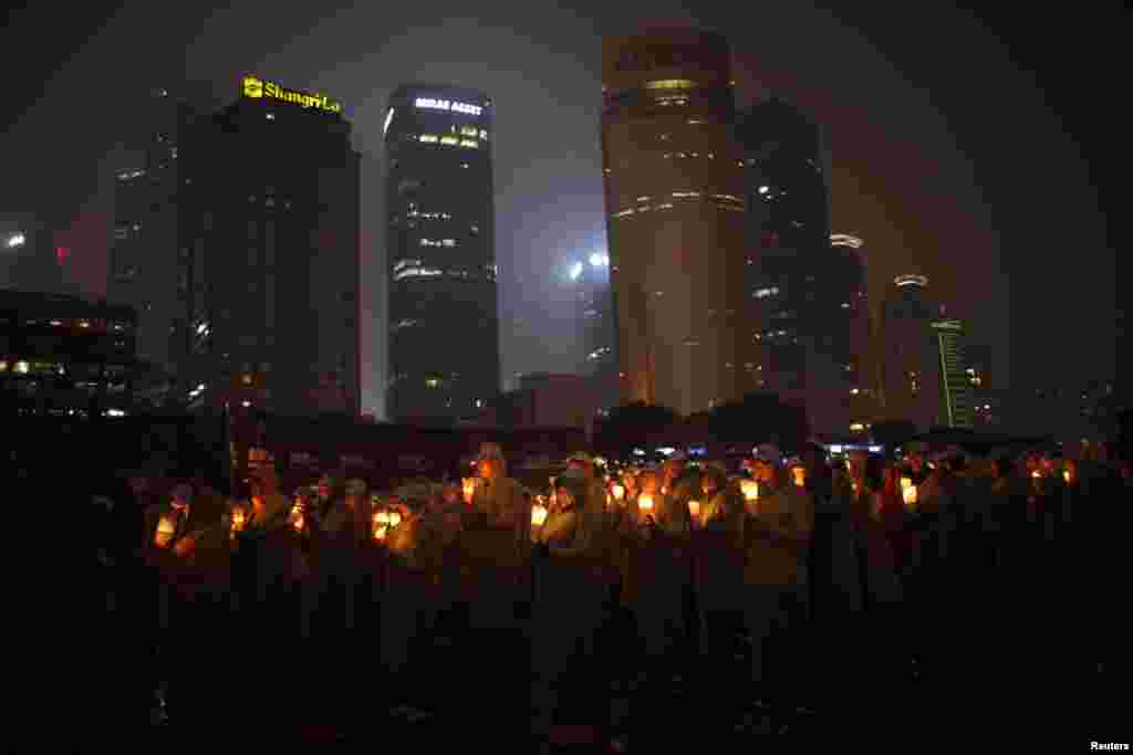 Warga di Shanghai memegang lilin pada acara yang dimaksudkan untuk masuk dalam catatan dunia Guinness "meniup lilin terbanyak secara bersamaan." Acara itu diadakan untuk memperingat Earth Hour.