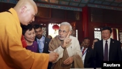 Indian Prime Minister Narendra Modi (C) gestures as he visits the Daxingshan Buddhist temple, in Xian, Shaanxi province, China, May 14, 2015.