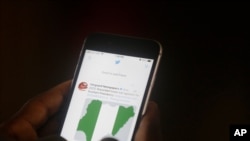 Un homme utilise son téléphone portable pour lire les gros titres de Twitter dans un bureau à Lagos, au Nigeria, le 7 juin 2021.