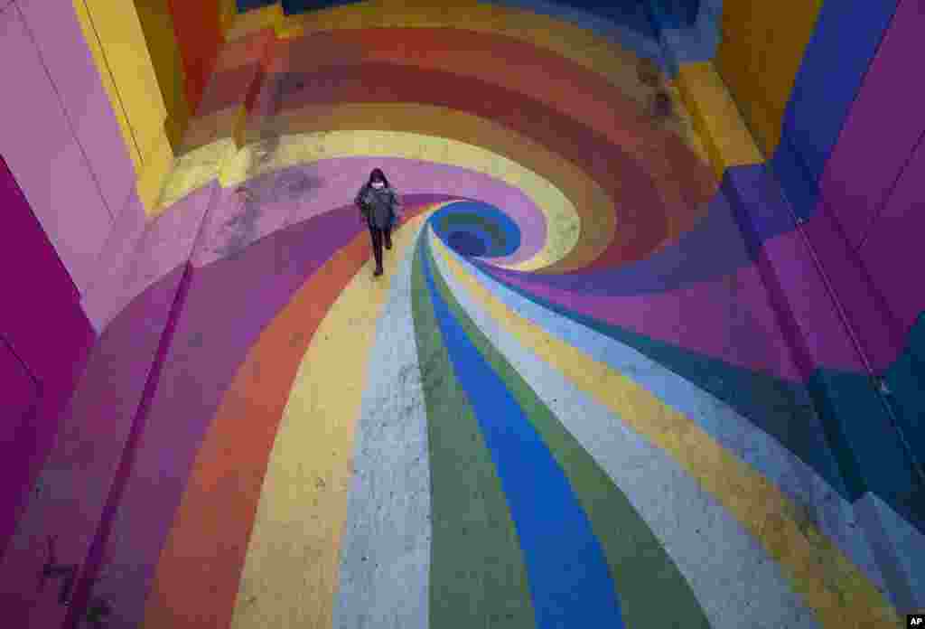 A woman walks through the rainbow-colored Paseo Bandera in Santiago, Chile, April 27, 2021, which is empty due to the coronavirus pandemic.