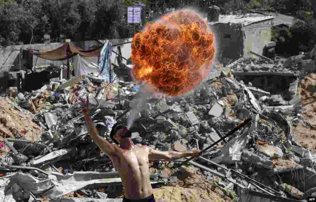 Palestinian members of Gaza's Bar Woolf sports team perform with fire on the ruins of a building destroyed in recent Israeli airstrikes, in Beit Lahia.