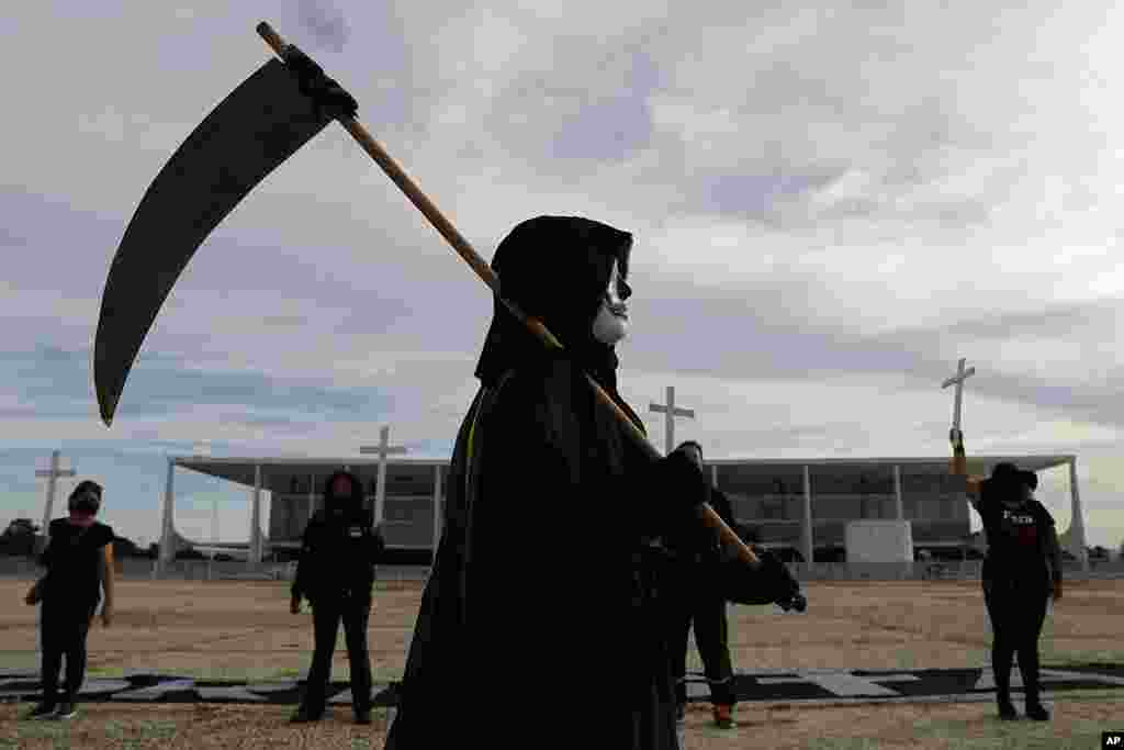 A demonstrator dressed as Death performs outside Planalto presidential palace to protest the president's handling of the COVID-19 pandemic in Brasilia, Brazil. Brazil surpassed 300,000 deaths from the virus this week.