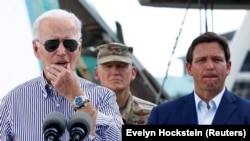 Rais wa Marekani Joe Biden (kushoto) akiwa na Gavana wa Florida Ron DeSantis