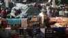 Migrants settle in the logistics center of the checkpoint "Bruzgi" at the Belarus-Poland border near Grodno, Belarus, Wednesday, Dec. 1, 2021.