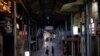 FILE - Passersby wearing protective face masks, amid the COVID-19 pandemic, walk at a shopping arcade in the prefectural capital Naha, on the southern island of Okinawa, Okinawa prefecture, Japan, Oct. 24, 2021.