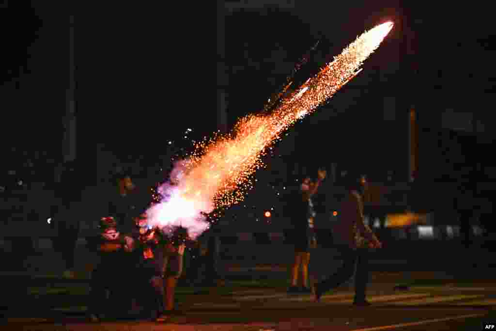 Protesters set off fireworks as they take part in a demonstration in Bangkok, calling for the resignation of Thailand's Prime Minister Prayut Chan-O-Cha over the government's handling of the Covid-19 coronavirus crisis.