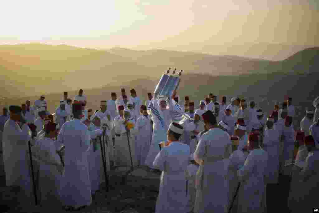 A member of the ancient Samaritan community holds up a Tora scroll as worshippers pray during the Passover pilgrimage at the religion's holiest site on the top Mt. Gerizim, near the West Bank town of Nablus.