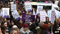 FILE - People hold placards against women's violence as they take part in a protest during the international day for elimination of violence against women in Paris, Nov. 23, 2019. 