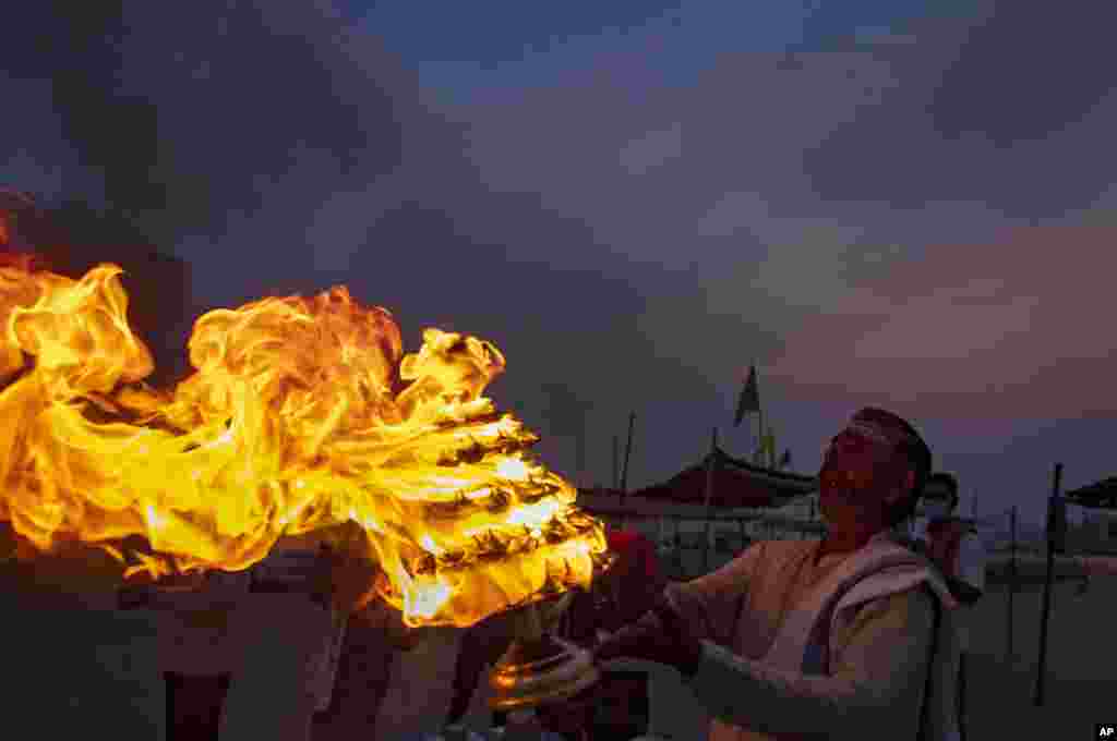 A Hindu priests perform an evening ritual "Aarati" at Sangam, the confluence of the rivers Ganges and Yamuna on Ramnavami in Prayagraj, India.
