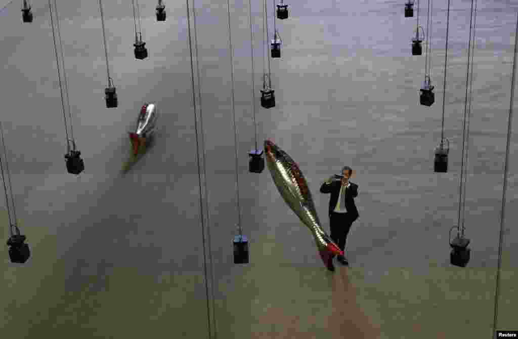 A man takes a picture of the installation "Anywhere" by French artist Philippe Parreno, in the Turbine Hall at Tate Modern in central London, Britain.