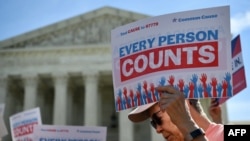 FILE - Demonstrators rally at the U.S. Supreme Court in Washington, April 23, 2019, to protest a proposal to add a citizenship question in the 2020 Census.