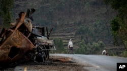 Mtu mmoja akivuka karibu na lori lililoharibiwa kwenye barabara inayoelekea mji wa Abi Adi, katika eneo la Tigray kaskazini mwa Ethiopia wakati wa mapigano Mei 11, 2021.