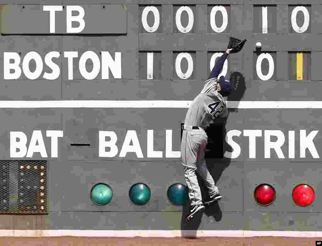 Pemain baseball klub 'Tampa Bay Rays', Matt Joyce gagal menangkap bola pukulan dari pemain 'Boston Red Sox' Stephen Drew selama pertandingan di lapangan Fenway Park di Boston, Massachusetts.