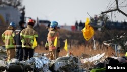 Спасатели разбирают обломки самолета, который разбился после взлёта в международном аэропорту Муан, Южная Корея, 29 декабря 2024 г.