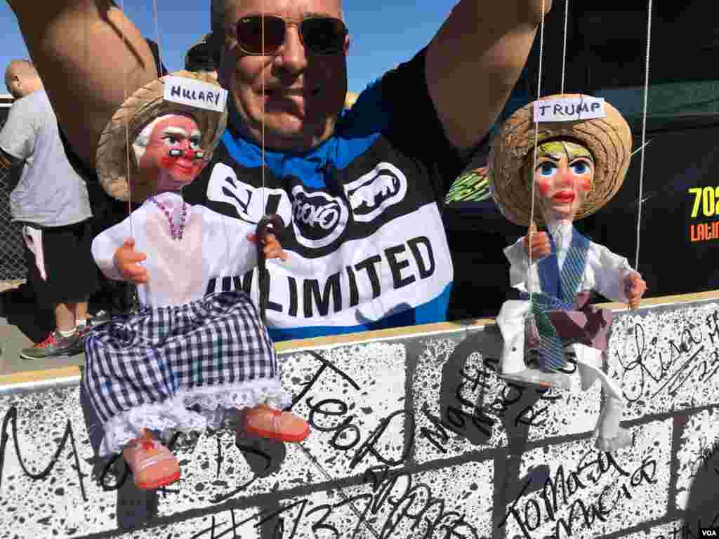 Seorang pria memegang boneka Donald Trump dan Hillary Clinton di Las Vegas, Nevada, tak jauh dari lokasi debat capres AS yang ketiga, 19 Oktober 2016. (J. Oni/VOA)