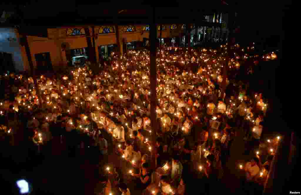 Participants hold candles during a mass prayer to call for justice in the trials of dissident blogger Nguyen Huu Vinh and land protection activist Can Thi Theu, at the Thai Ha Church in Hanoi, Vietnam, Sept. 18, 2016.