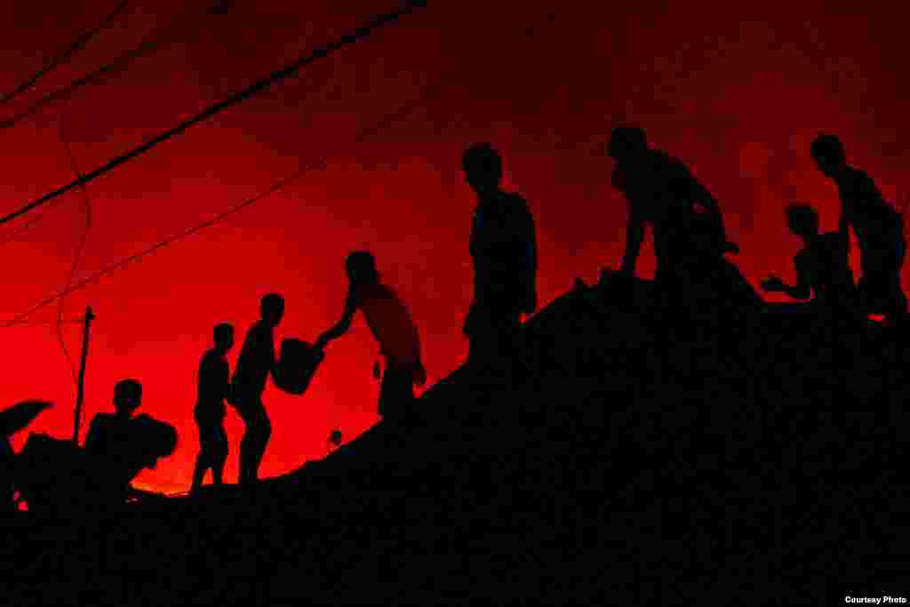 Atho Ullah dari Indonesia dengan fotonya berjudul "The Fire Fighters", tentang warga Karang Anyar, Jakarta Pusat, yang bergotong royong memadamkan api.