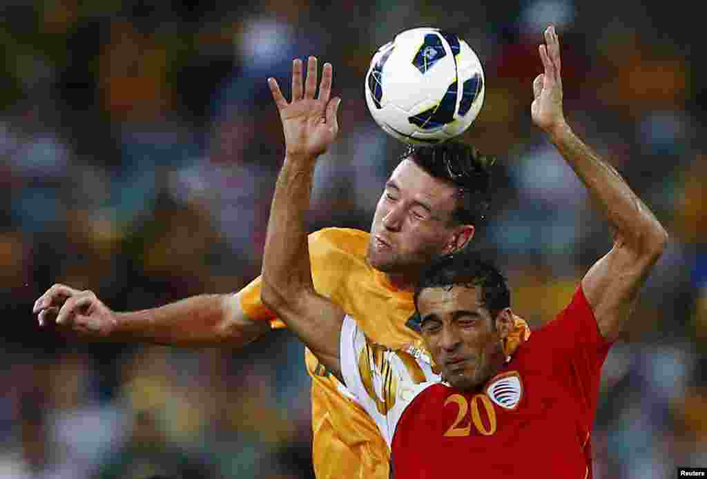 Pemain timnas Oman, Amad Al Hosni (kanan) berebut bola dengan pemain Australia Robert Cornthwaite dalam pertandingan kualifikasi sepakbola Pra Piala Dunia di Sydney, Australia.