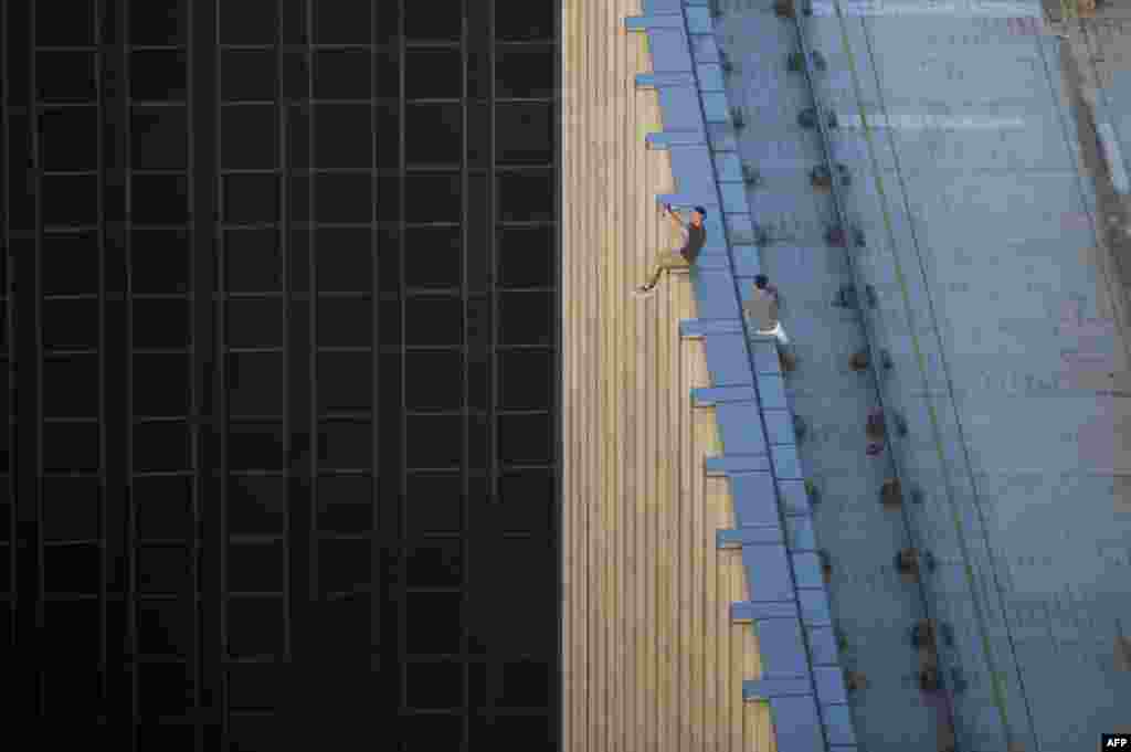 Dua pemuda mengambil foto selfie di atas gedung pencakar langit, aksi yang dikenal sebagai "rooftopping" di Hong Kong.