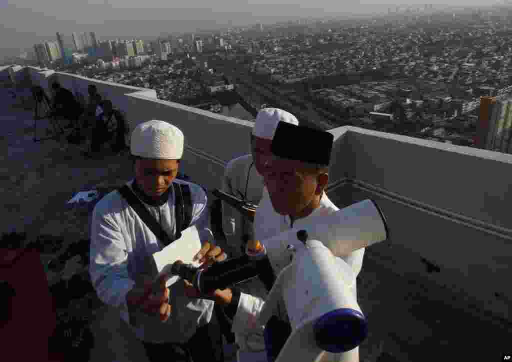 Para ulama bersiap meneropong bulan sabit yang akan menentukan awal bulan puasa Ramadan di Jakarta (8/7). (AP/Achmad Ibrahim)