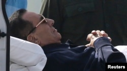 Former Egyptian President Hosni Mubarak lies on a stretcher while being transported ahead of his trial in Cairo, Sept. 27, 2014. 