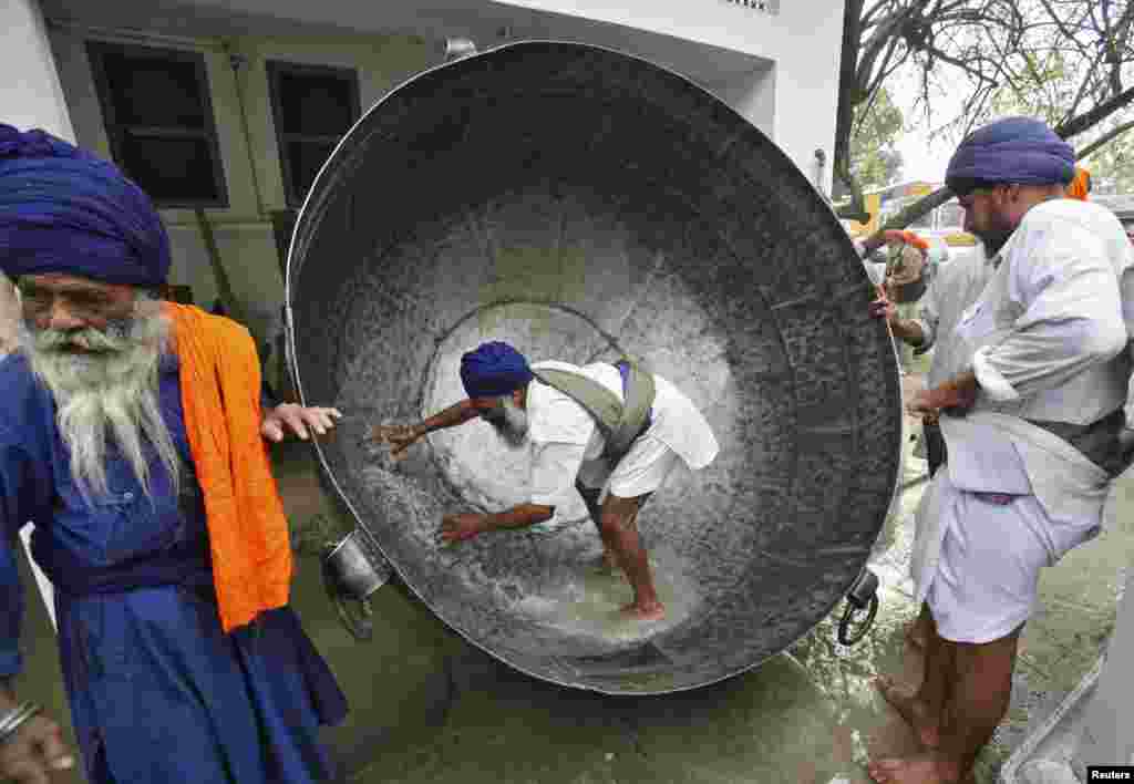 Seorang pria membersihkan panci besar untuk menyiapkan minuman non-alkohol selama perayaan festival Hola Mohalla di kota Anandpur Sahib, negara bagian Punjab, India utara. "Hola Mohalla" adalah festival yang dirayakan oleh kaum Sikh dari seluruh India, yang dirayakan bersamaan dengan festival agama Hindu Holi.