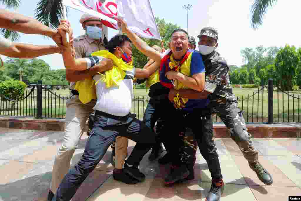 Police officers detain Tibetan demonstrators during a protest against Chinese Communist Party's 100-year anniversary celebrations, outside Chinese Embassy in New Delhi, India.