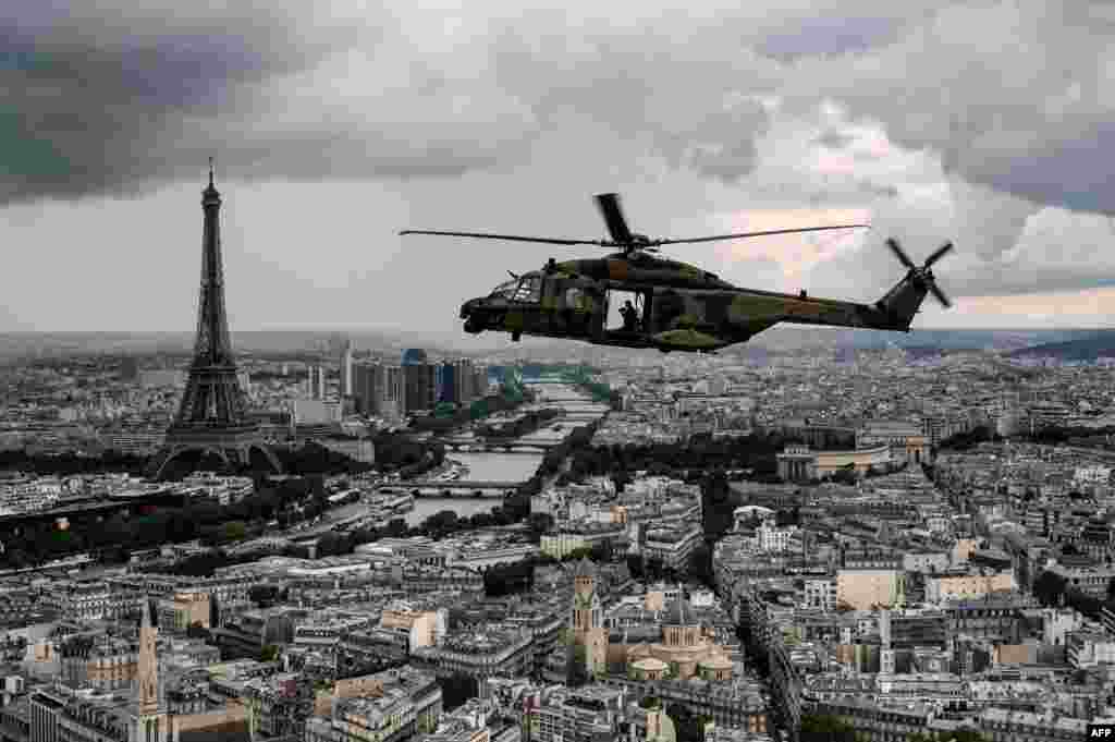 An NH90 "CAIMAN" helicopter flies over the Eiffel Tower and the Seine river during a practice session prior to July 14's Bastille Day Parade in Paris, France.