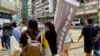 香港言語治療師總工會主席黎雯齡（手持旗幟者）與兩名成員，今年7-1在港島銅鑼灣及灣仔一帶做”流動街站”，呼籲市民繼續發聲，爭取民主 (美國之音/湯惠芸)