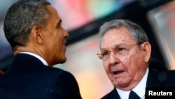 U.S. President Barack Obama greets Cuban President Raul Castro at memorial service for late South African President Nelson Mandela, Johannesburg, Dec. 10, 2013.