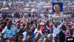 A man holds up a painted portrait of Edward Lowassa, former prime minister of Tanzania and presidential candidate for UKAWA, a coalition of four main opposition parties, during a political rally in Dar es Salaam, Tanzania, Aug. 29, 2015.