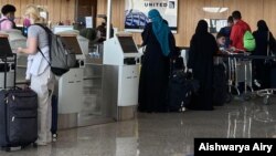 FILE - Passengers check in for a flight at Dulles International Airport in Virginia, outside Washington, D.C., July 16, 2020. (Aishwarya Airy/VOA)