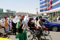 Un hombre vende banderas talibanes en la provincia de Herat, al oeste de Kabul, Afganistán, el sábado 14 de agosto de 2021.