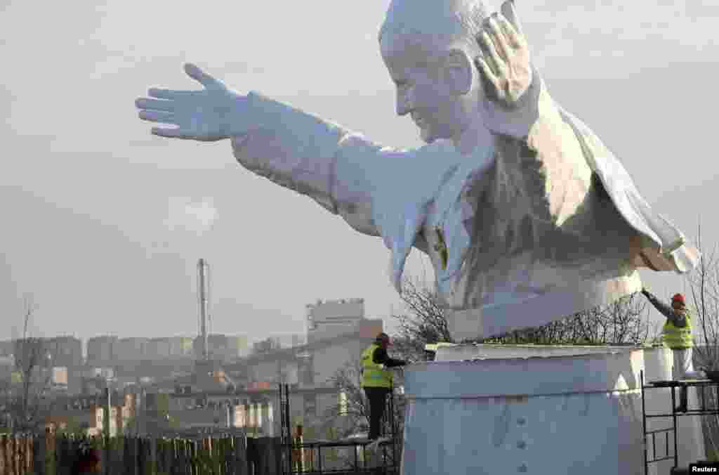 Para pekerja menyelesaikan sebuah monumen peringatan untuk mendiang Paus Yohanes Paulus II, di kota Czestochowa, Polandia selatan. Monumen setinggi 14 meter ini akan dibuka untuk umum pada tanggal 13 April.