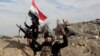 Iraqi security forces raise an Iraqi flag near the provincial council building in central Ramadi on Sunday.