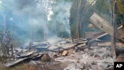 ফাইল- ম্যাগওয়ে অঞ্চলের তাওং মিন্ট গ্রামের একটি স্কুল ভবনের কুঞ্চিত ছাদ এবং আবর্জনা থেকে ধোঁয়া বের হচ্ছে।মিয়ানমার, ১৬ অক্টোবর ২০২২।