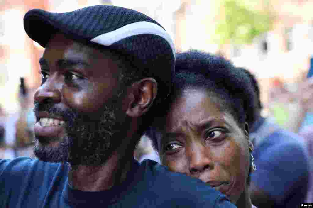 Tanya and Evance Chanda from Mechanicsville look on as a statue of Confederate General Thomas "Stonewall" Jackson is removed after years of a legal battle over the contentious monument, in Charlottesville, Virginia, July 10, 2021.