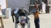 Los niños empujan una silla de ruedas con sus pertenencias mientras los palestinos huyen de Rafah debido a una operación militar israelí, en medio del conflicto entre Israel y Hamas, en Rafah, en el sur de la Franja de Gaza, el 13 de junio de 2024.