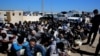 African illegal migrants wait to receive medial assistance after being rescued by coastal guards at a port in Tripoli, Libya, April 11, 2016.
