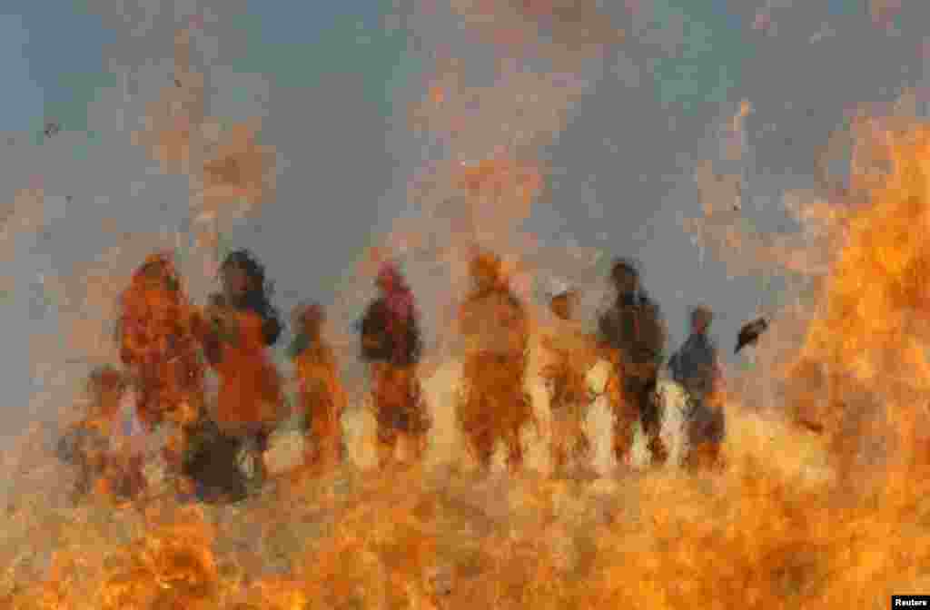 Anak-anak Afghanistan menyaksikan pembakaran obat dan makanan yang kadaluarsa di luar kota Jalalabad. (Reuters/Parwiz)
