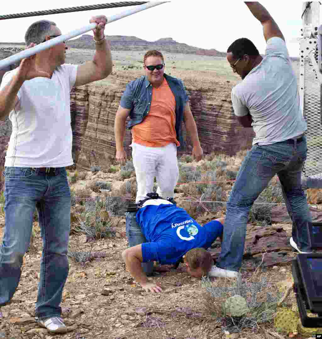 Aerialist Nik Wallenda kisses the ground after walking a 2-inch-thick steel cable that took him a quarter mile over the Little Colorado River Gorge. 